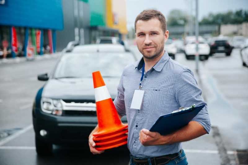 driving instructor collecting plastic cones
