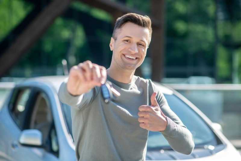 happy man with car key street