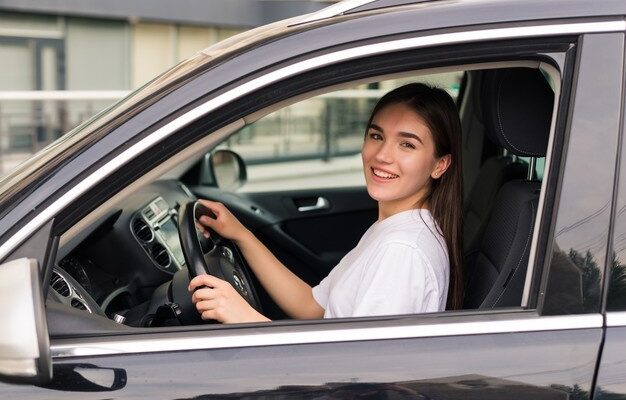 young beautiful smiling girl driving a car on the road 231208 11927