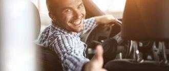 close up modern man sitting car showing his thumb up 1
